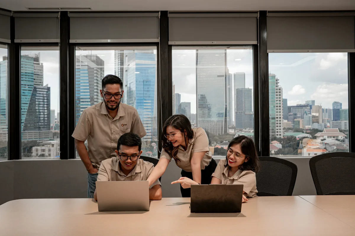 Colleagues working together around laptops in an office